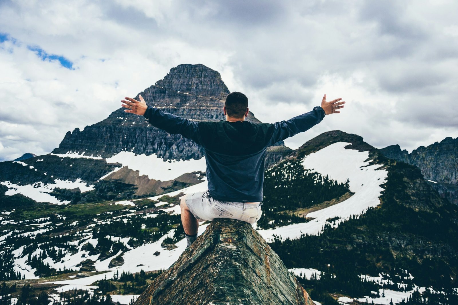 A victorious looking man on top of a mountain indicating a successful job search, finding an AI job.