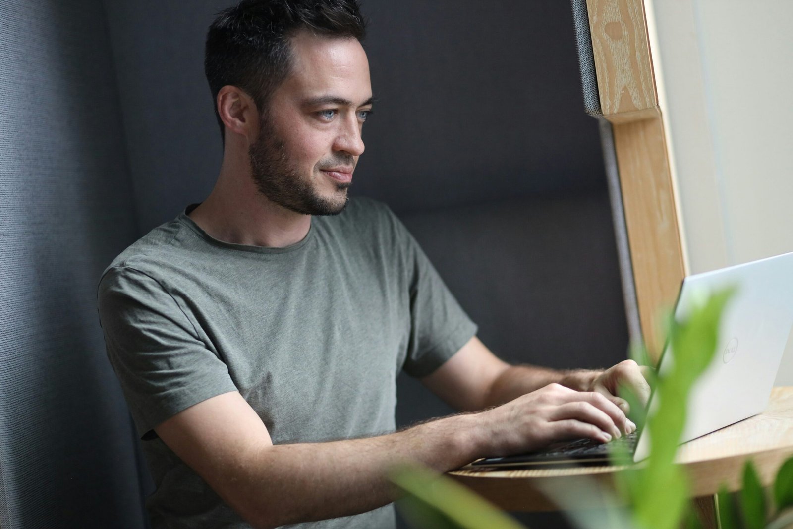 A young white man working on his laptop in a nice office.