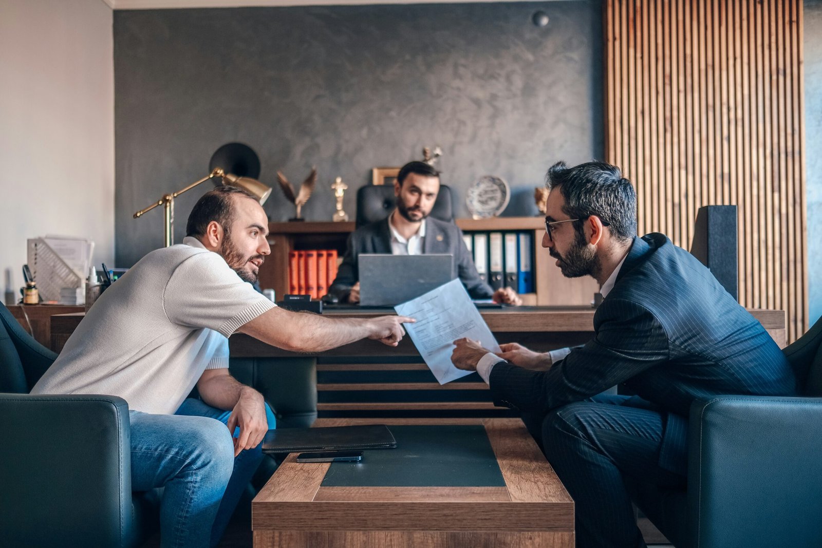 Two men in a job interview, one man on the left of pointing to a document